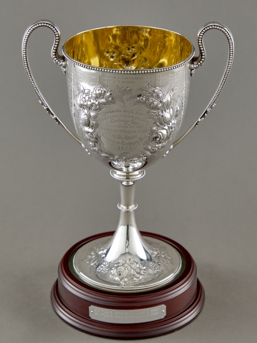 Silver athletics trophy, cup with large narrow handles and ornate fruit and foliage decoration