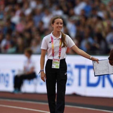 Female Official in while t-shirt and navy trousers on the track with a clipboard