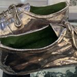 Pair of running shoes with spiked soles coated in silver