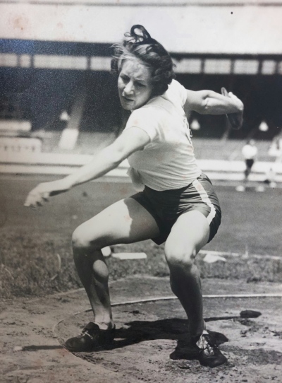 Black and white image of young woman in the process of throwing a discus