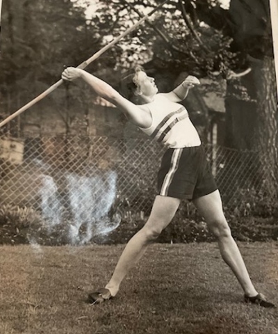 Black and white image of young woman throwing a javelin
