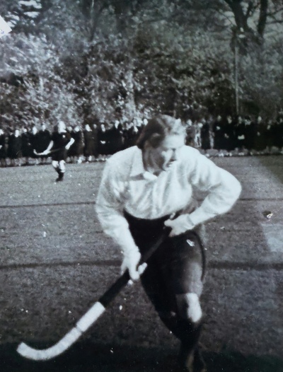 Black and white image of young woman playing hockey