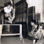 Jean at age 18 hurdling in school corridor